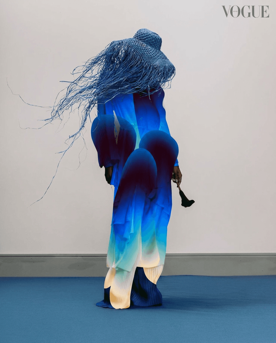 Woman wearing a flowing blue garment with an artistic design.
