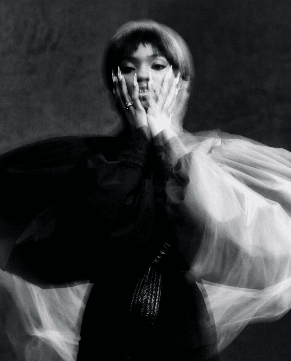 High-contrast black and white portrait of a woman with flowing fabric.