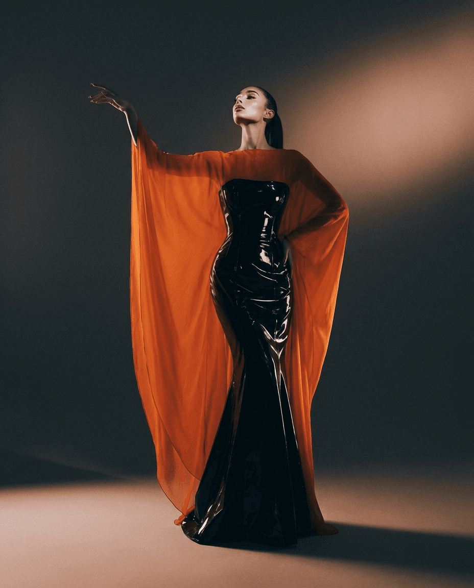 A woman wearing a striking orange and black gown in a luxurious setting.