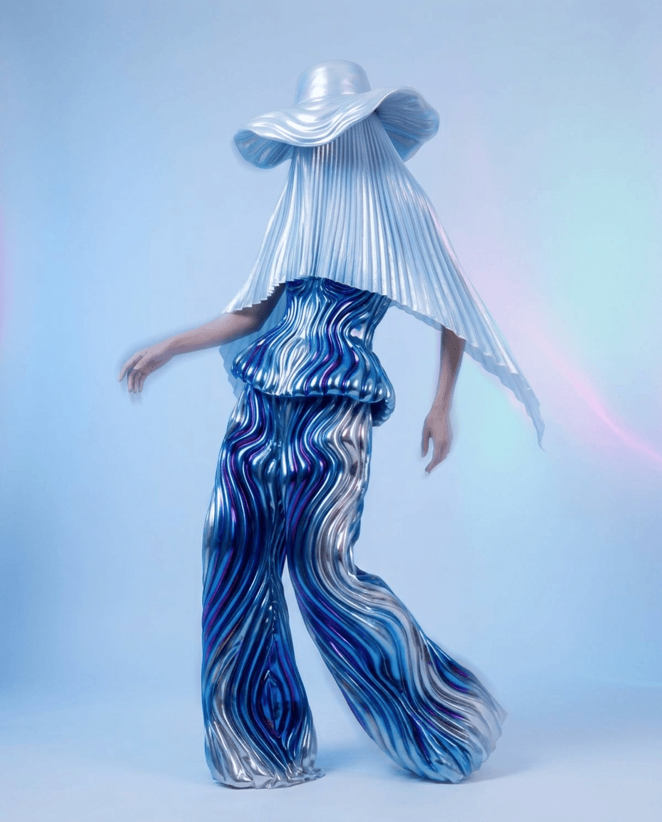 A woman in a flowing, iridescent outfit stands in ethereal lighting.