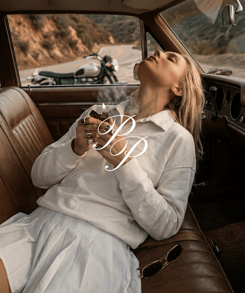 A woman reclining in the interior of a vintage car.
