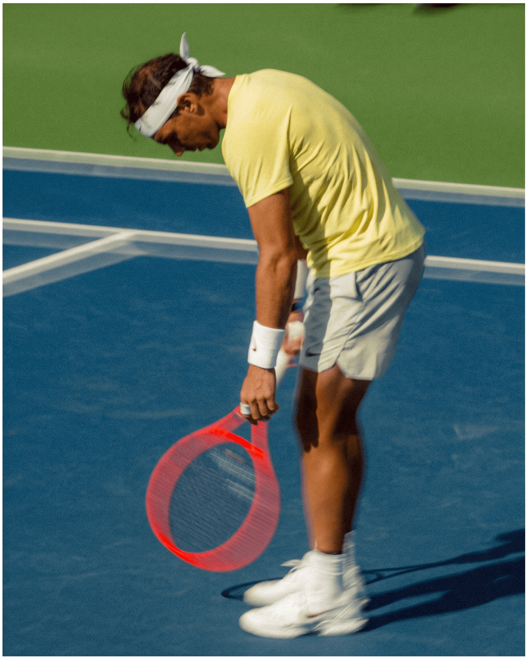 Male tennis player in action on a blue court with bright yellow accents.