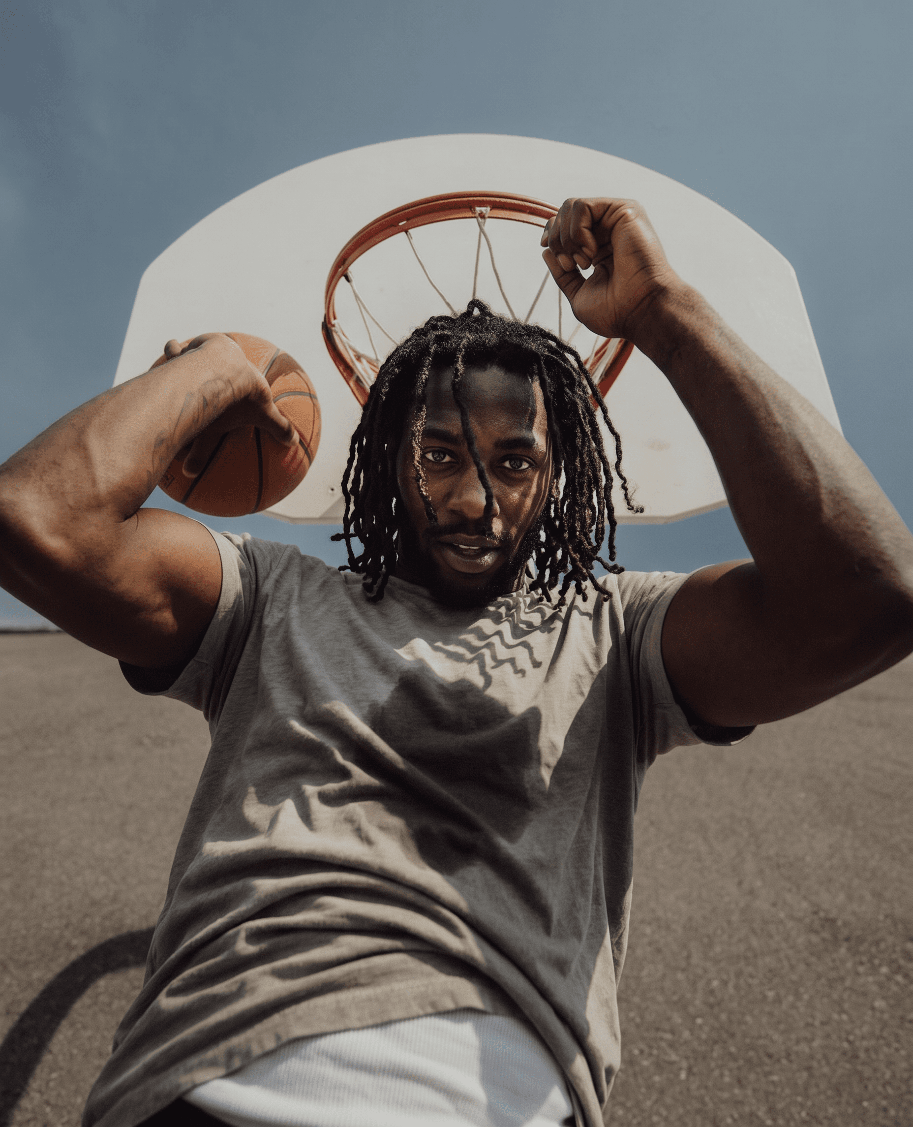 Full-figure portrait of a man with a basketball under a hoop.