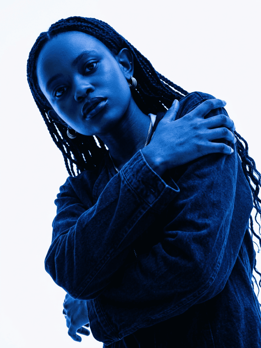 Portrait of a woman with braided hair illuminated in deep blue tones.
