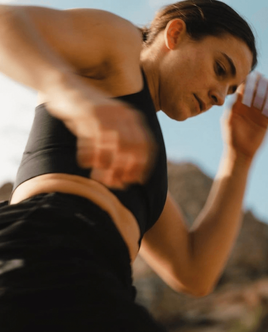 Low-angle shot of a woman in motion, featuring warm earth tones.