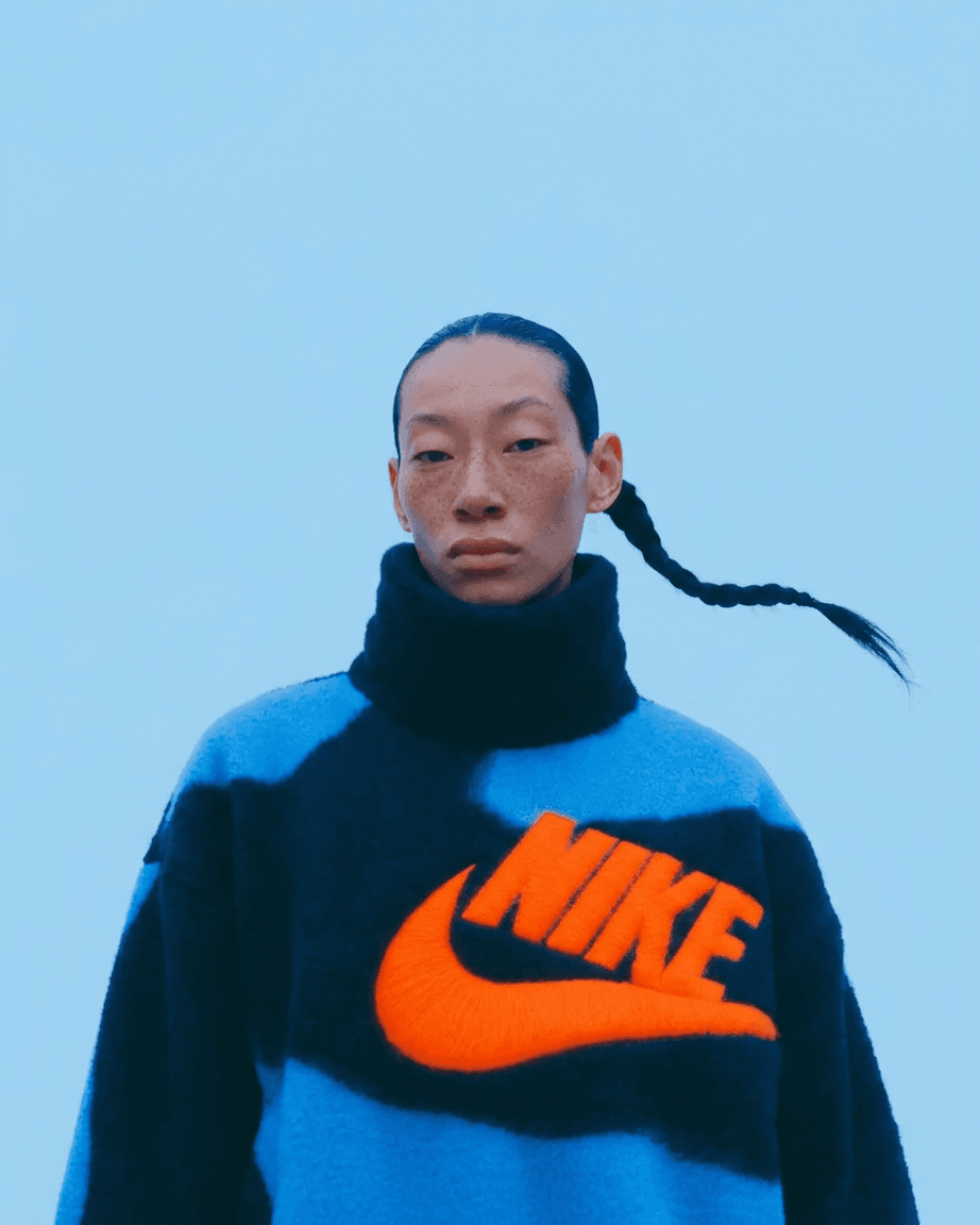 Portrait of a woman wearing a blue and black patterned sweater with the Nike logo.