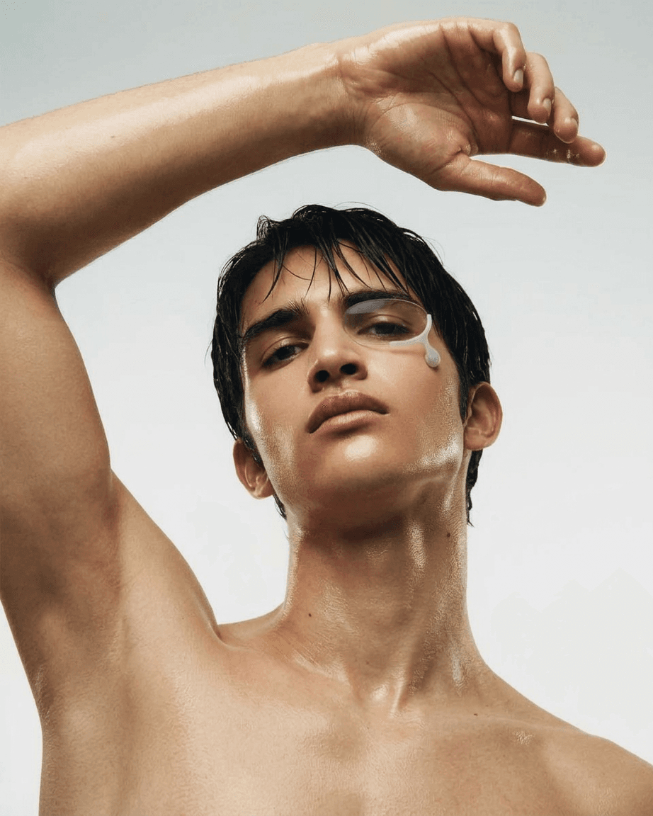 Close-up portrait of a young man with wet skin in soft white and neutral tones.