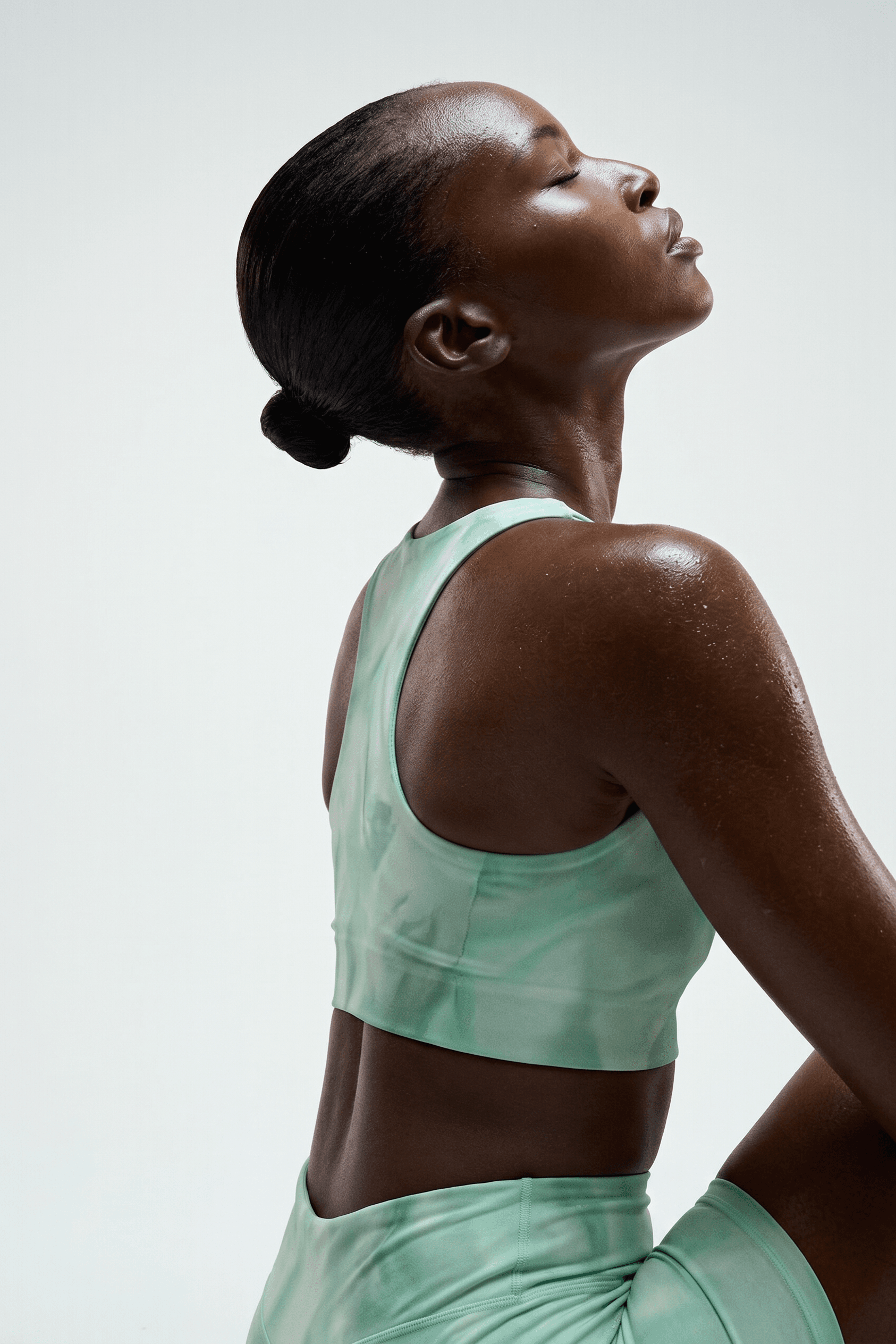 Profile portrait of a woman in athletic wear on a white background.