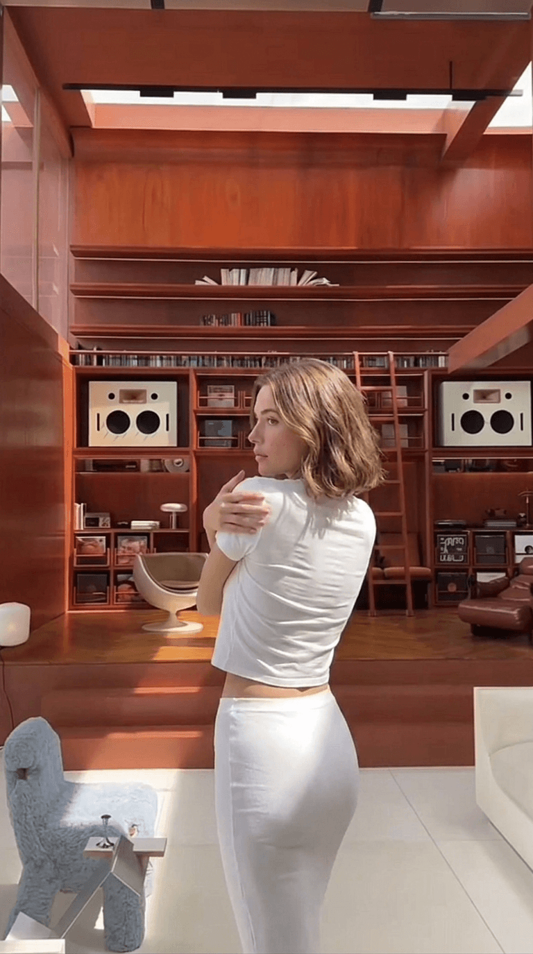 Portrait of a woman in a minimalist room with wooden furniture.