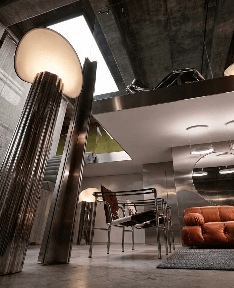 A modern interior with metallic furniture and a warm orange sofa.