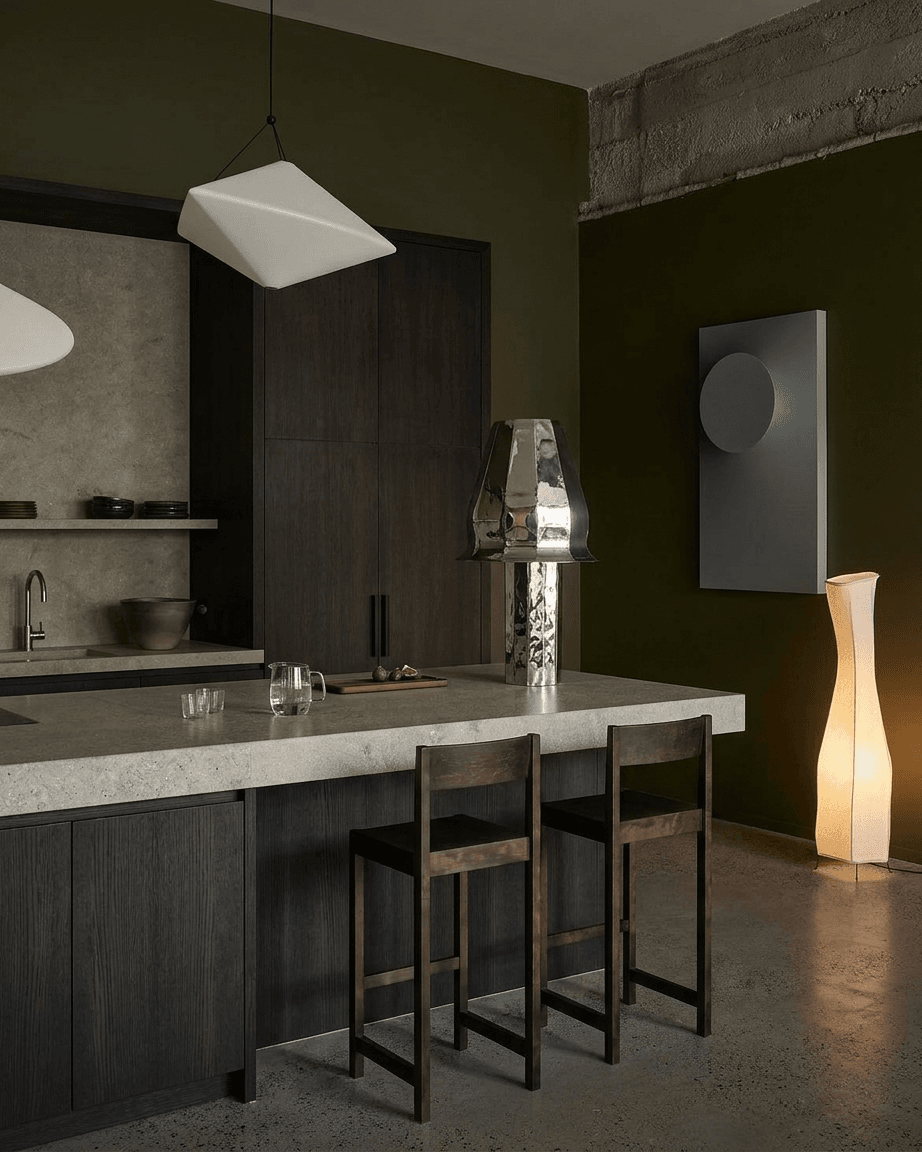 Modern kitchen with dark wood cabinets and concrete countertop, featuring warm lighting and earthy green accents.