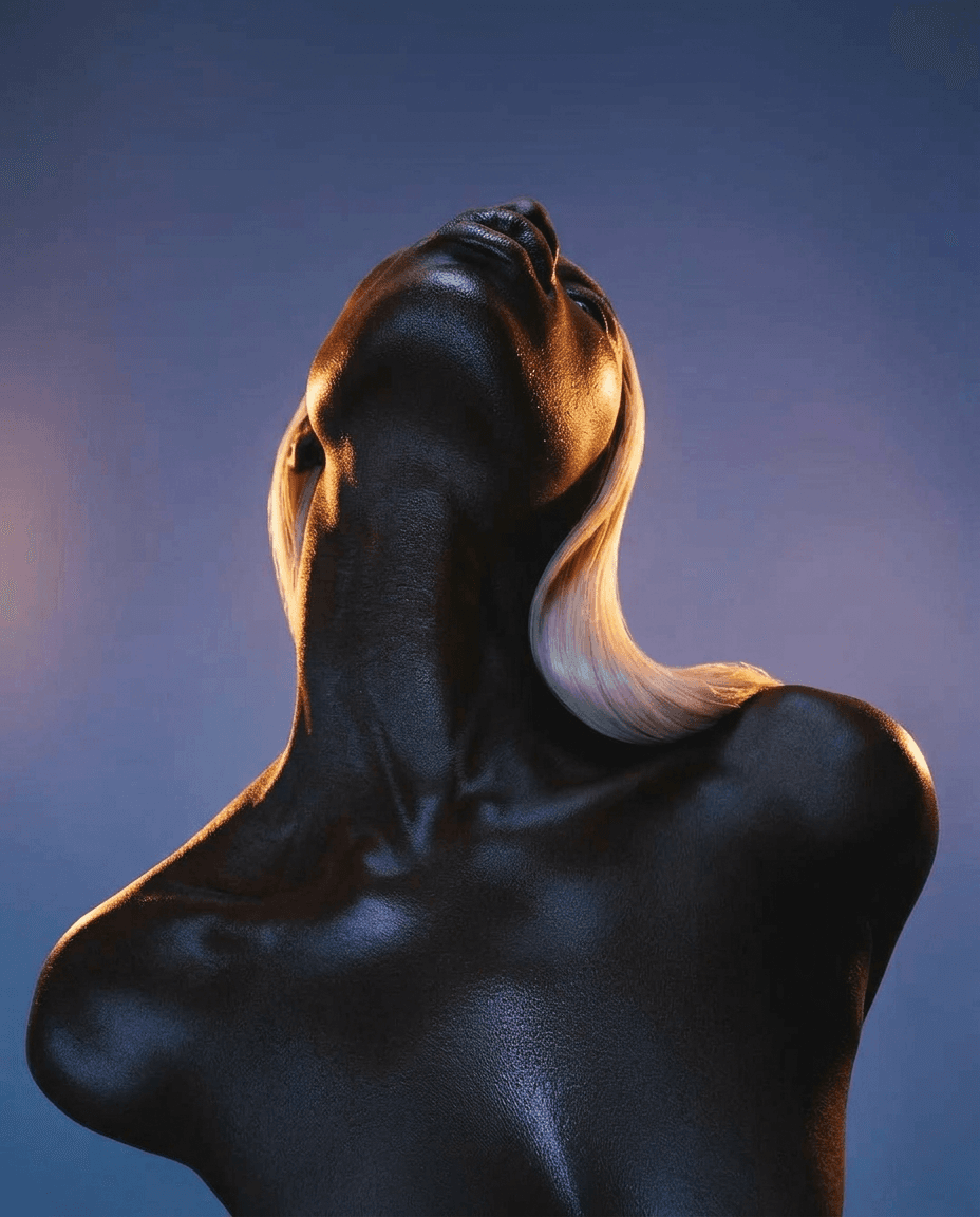 Low-angle photograph of a model with dark skin and blond hair, showcasing her neck and shoulders.