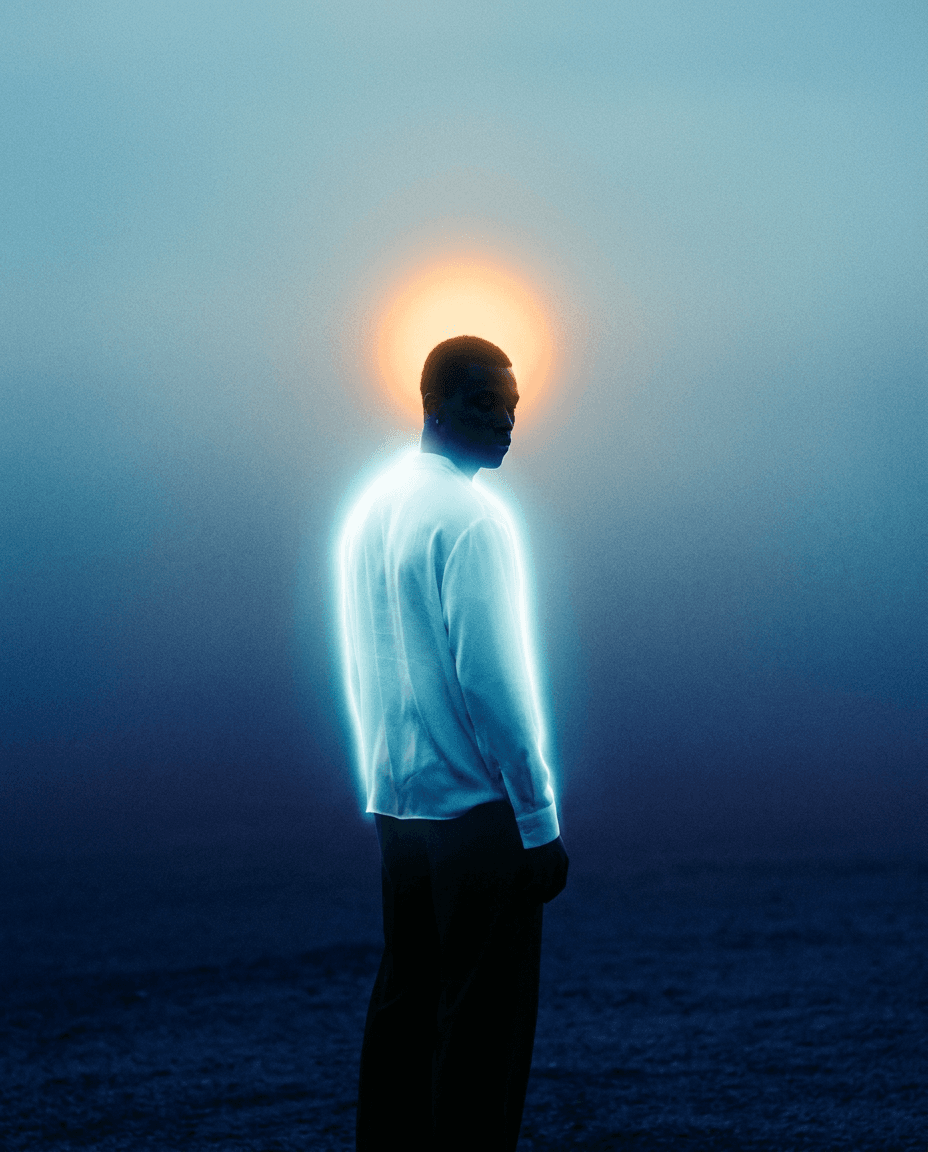 Silhouette of a man with a halo effect against a hazy background.
