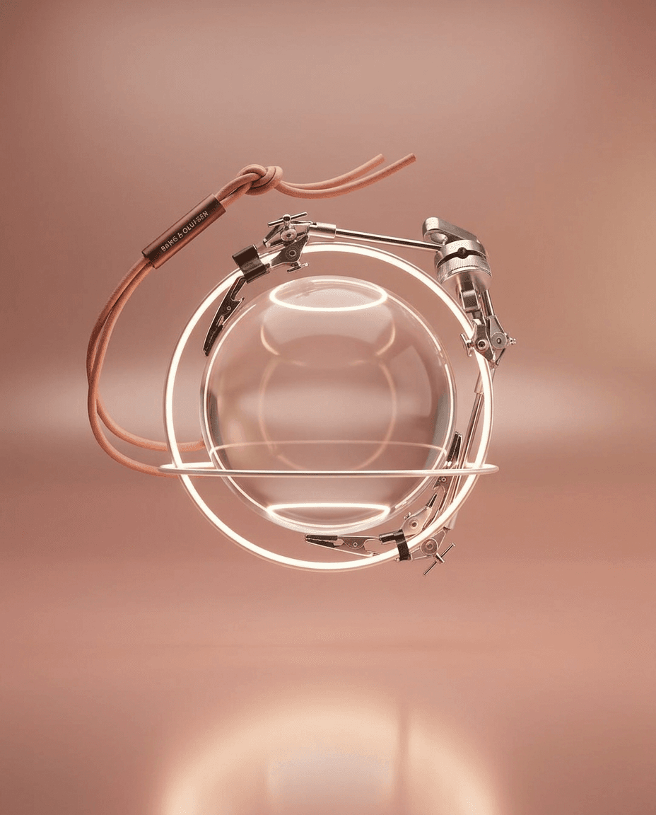 A transparent orb suspended in a metallic frame with warm pink and beige accents.
