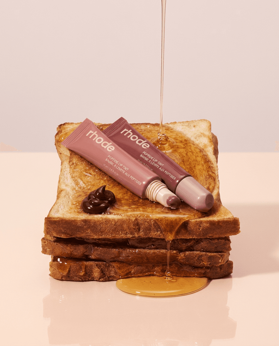 Makeup products arranged on toasted bread with honey dripping above.