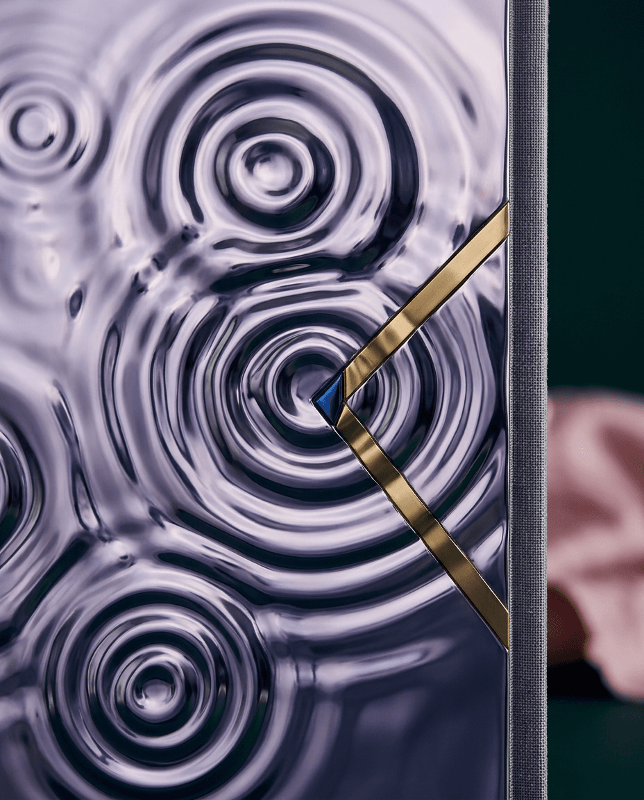 Close-up of a modern object with reflective surfaces and gold accents in deep purple.