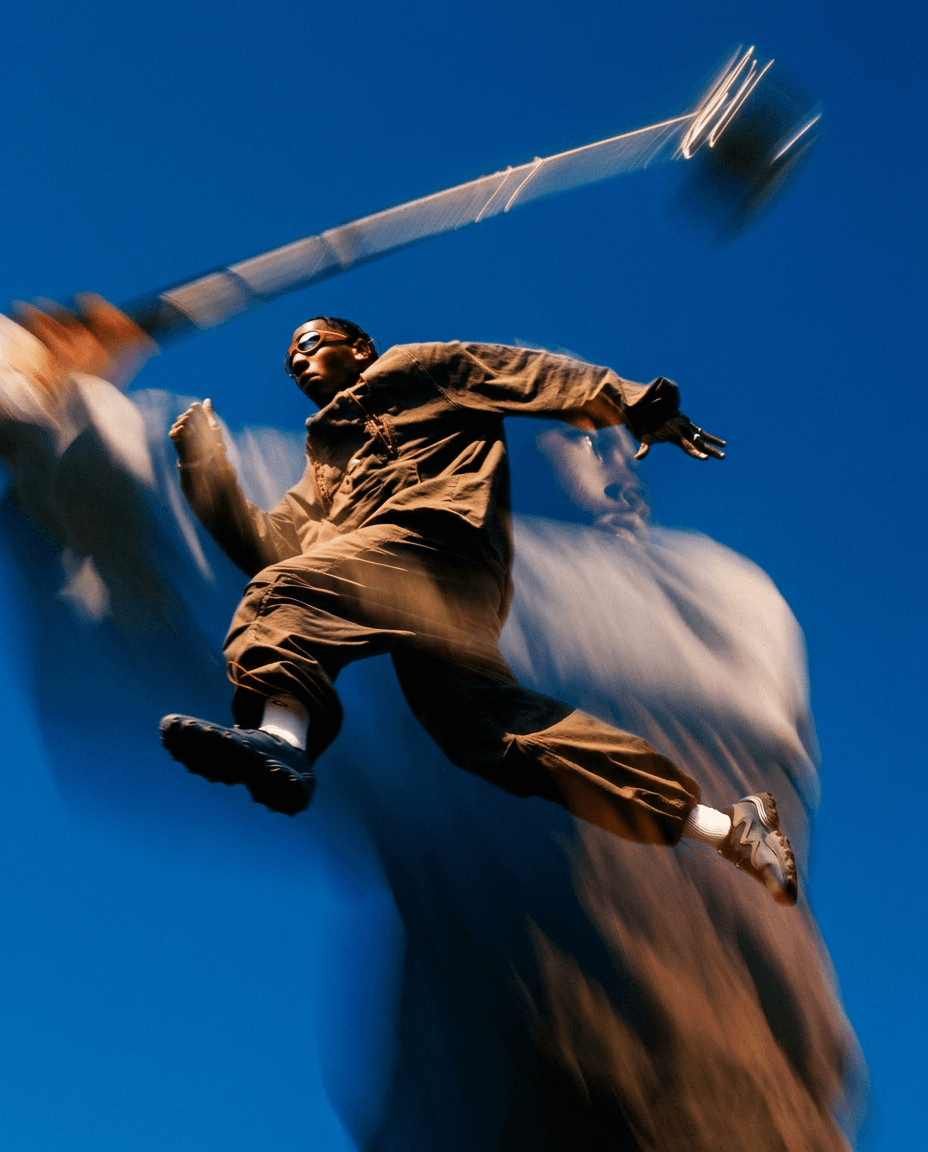 A figure leaps against a vibrant blue sky, with blurred motion effects.
