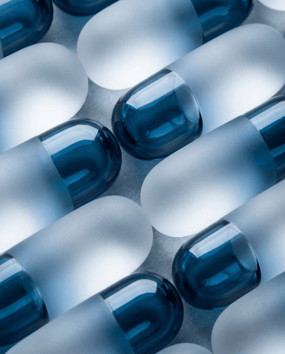 Close-up of frosted and glossy blue capsules in various shades.