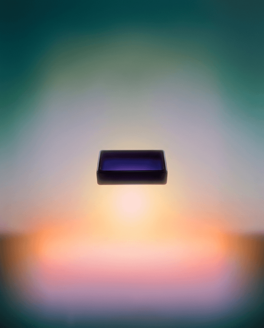 A dark rectangular object floats against a blurred pastel gradient background.