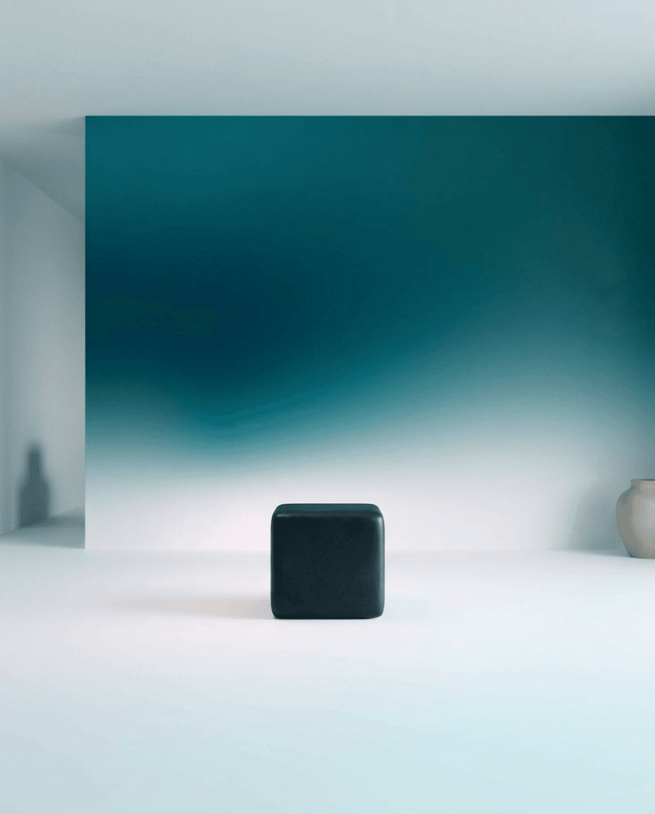 A black cube in the centre of a gradient background from teal to white.