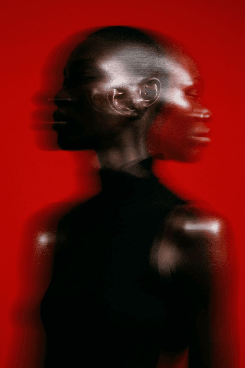 Portrait of a figure with overlapping profiles on a red background.