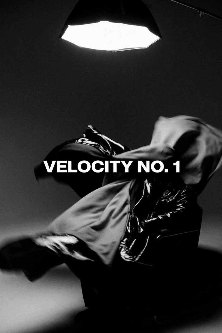 A figure in motion surrounded by flowing fabric on a black background.