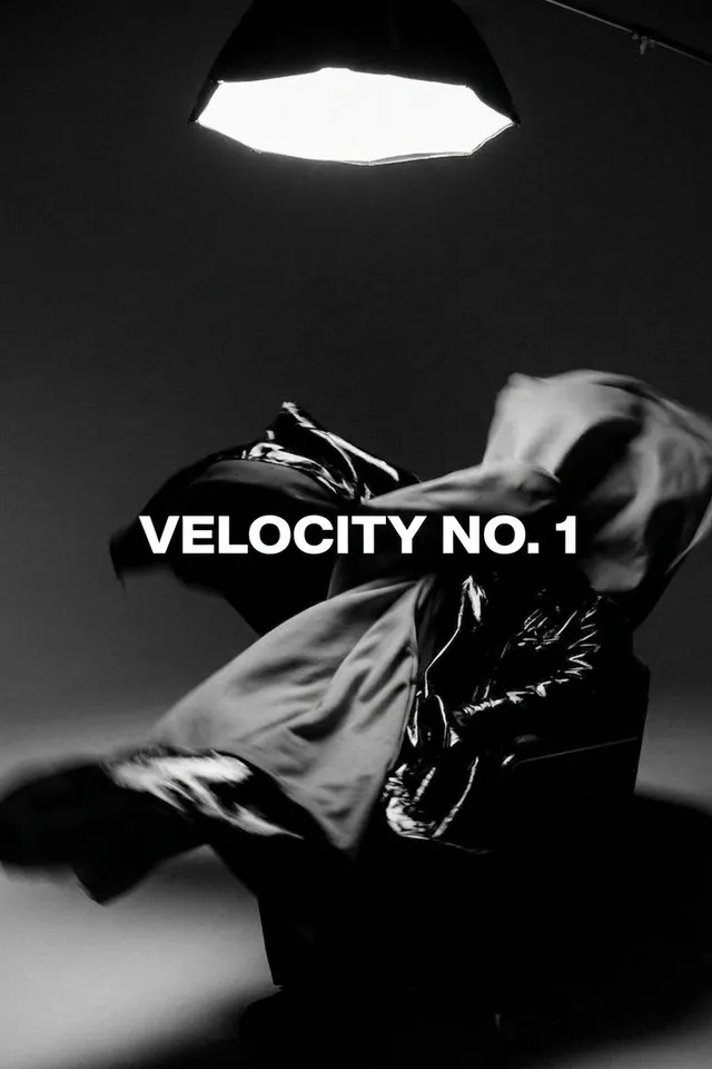 A figure in motion surrounded by flowing fabric on a black background.