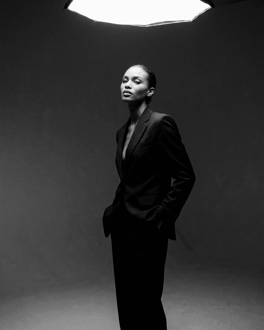 Black and white image of a confident model wearing a tailored suit.