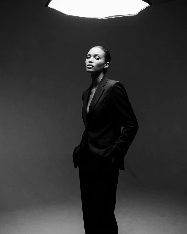 Black and white image of a confident model wearing a tailored suit.