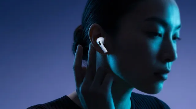 Close-up of a woman with AirPods on a blue and purple gradient background.