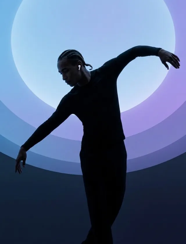 Silhouette of a dancer in a pose against a purple and blue gradient background.