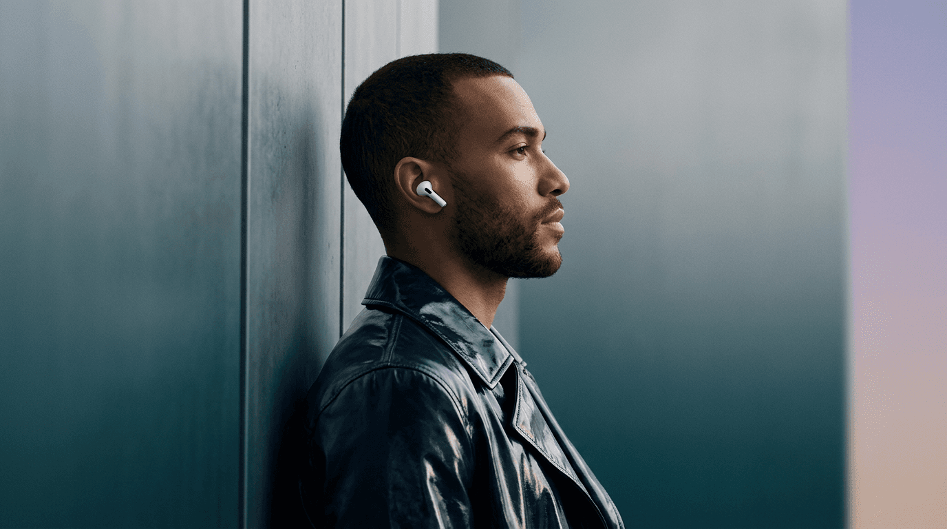 Man wearing wireless earbuds with a gradient background.