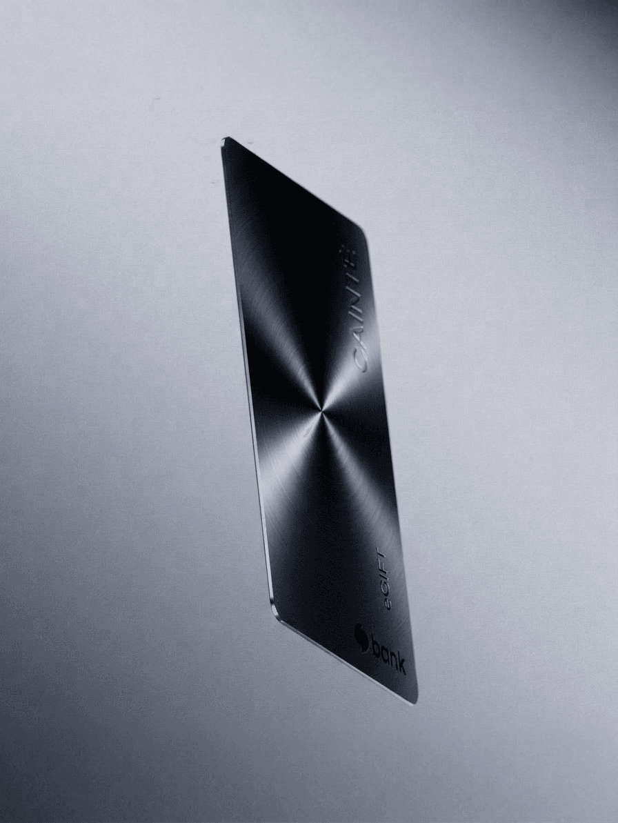 A metallic credit card floating on a gradient background of silver and gray.