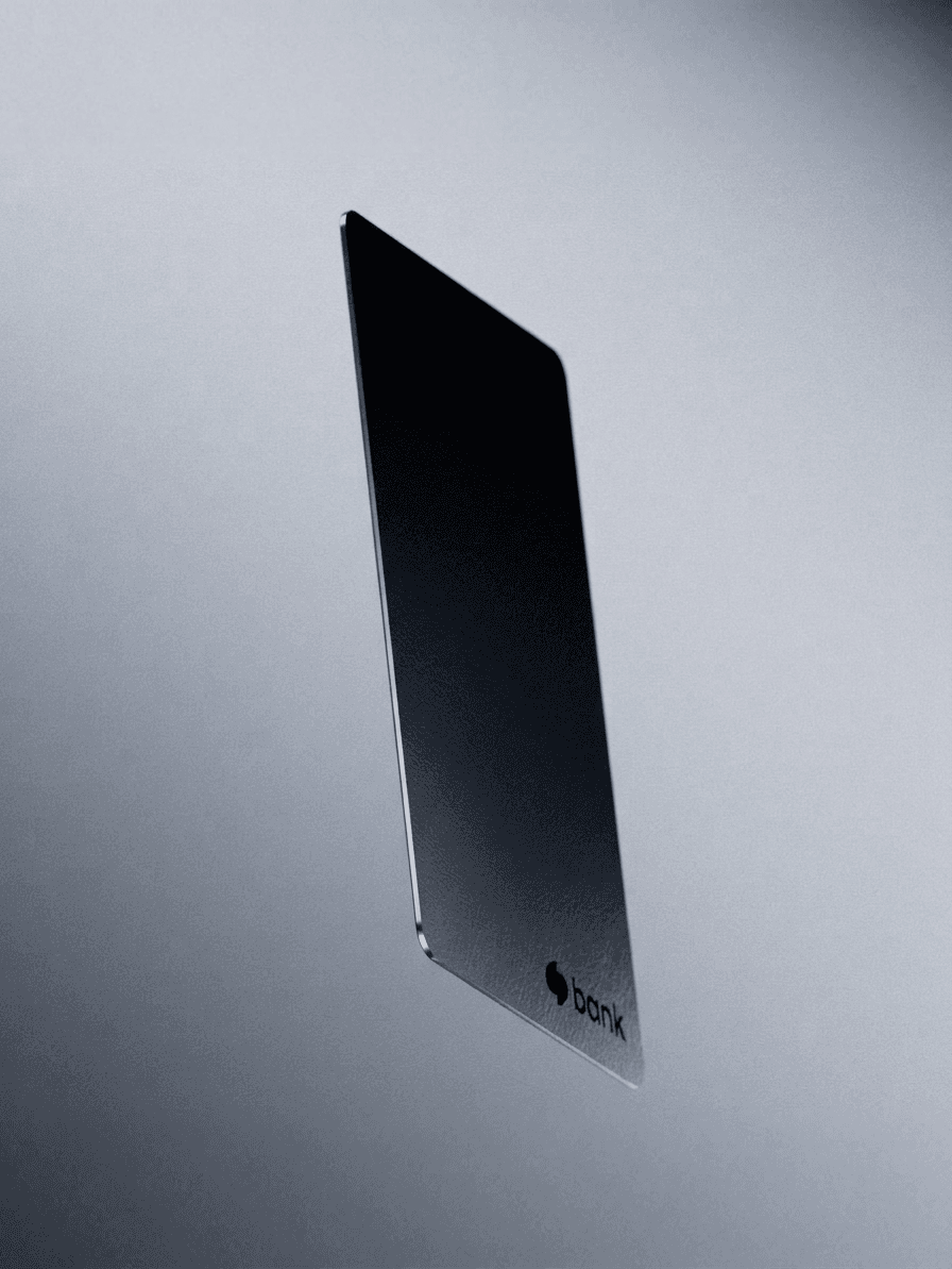 A sleek bank card floating on a blurred grey background.