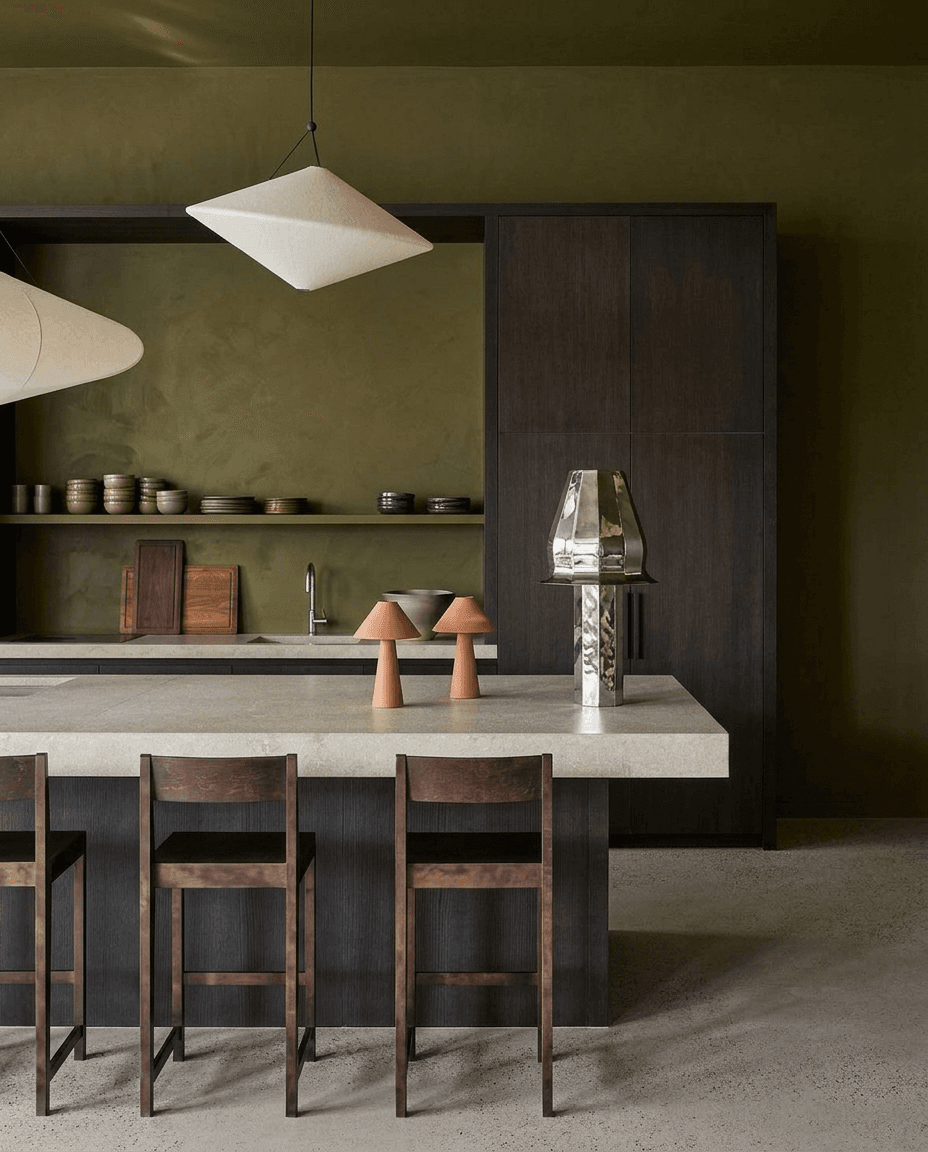 Minimalist kitchen scene with a concrete island and dark wood cabinets.